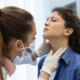 Doctor examines patient's neck